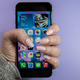 A photo of a person grasping the iPhone SE